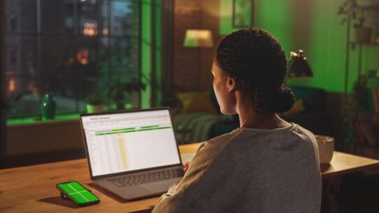 Pessoa trabalhando em laptop com planilha à noite.