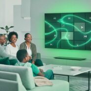 Família assistindo TV com design moderno e luzes verdes.
