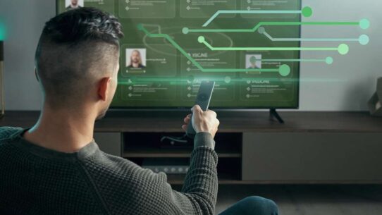 Homem assistindo TV com tecnologia digital interativa.
