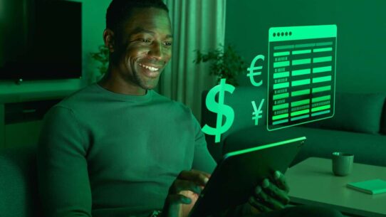 Homem sorrindo usando tablet com gráficos financeiros.