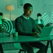 Homem usando laptop em ambiente caseiro com Wi-Fi.