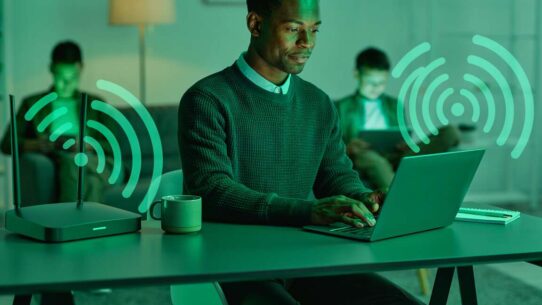 Homem usando laptop em ambiente caseiro com Wi-Fi.