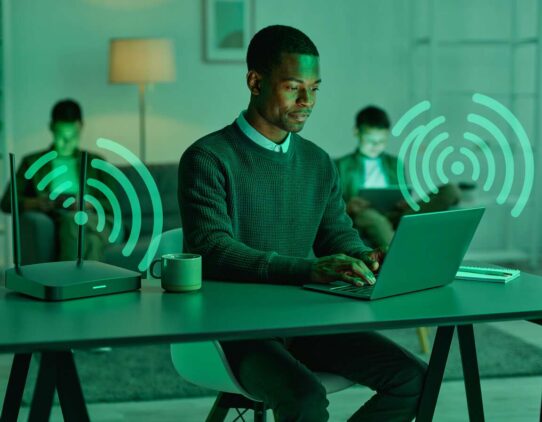 Homem usando laptop em ambiente caseiro com Wi-Fi.