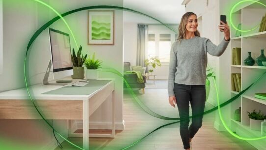 Mulher sorrindo usando smartphone em ambiente moderno.