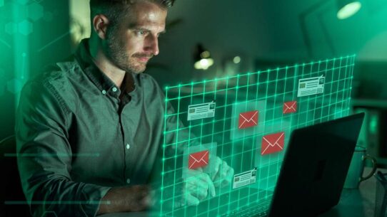 Homem analisando e-mails em computador moderno.