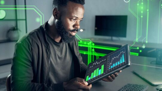 Homem analisando gráficos em tablet com dados digitais.