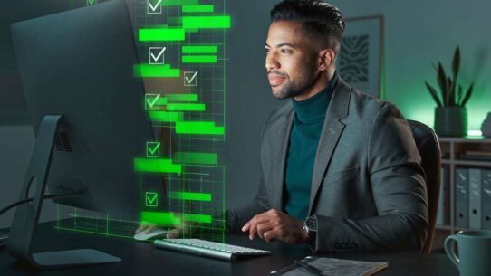 Homem em terno trabalhando em computador com gráficos.