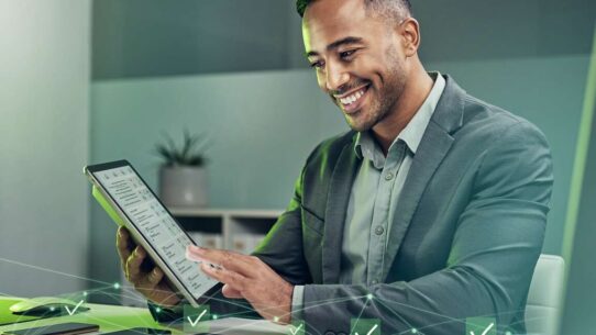 Homem sorridente usando tablet em escritório moderno