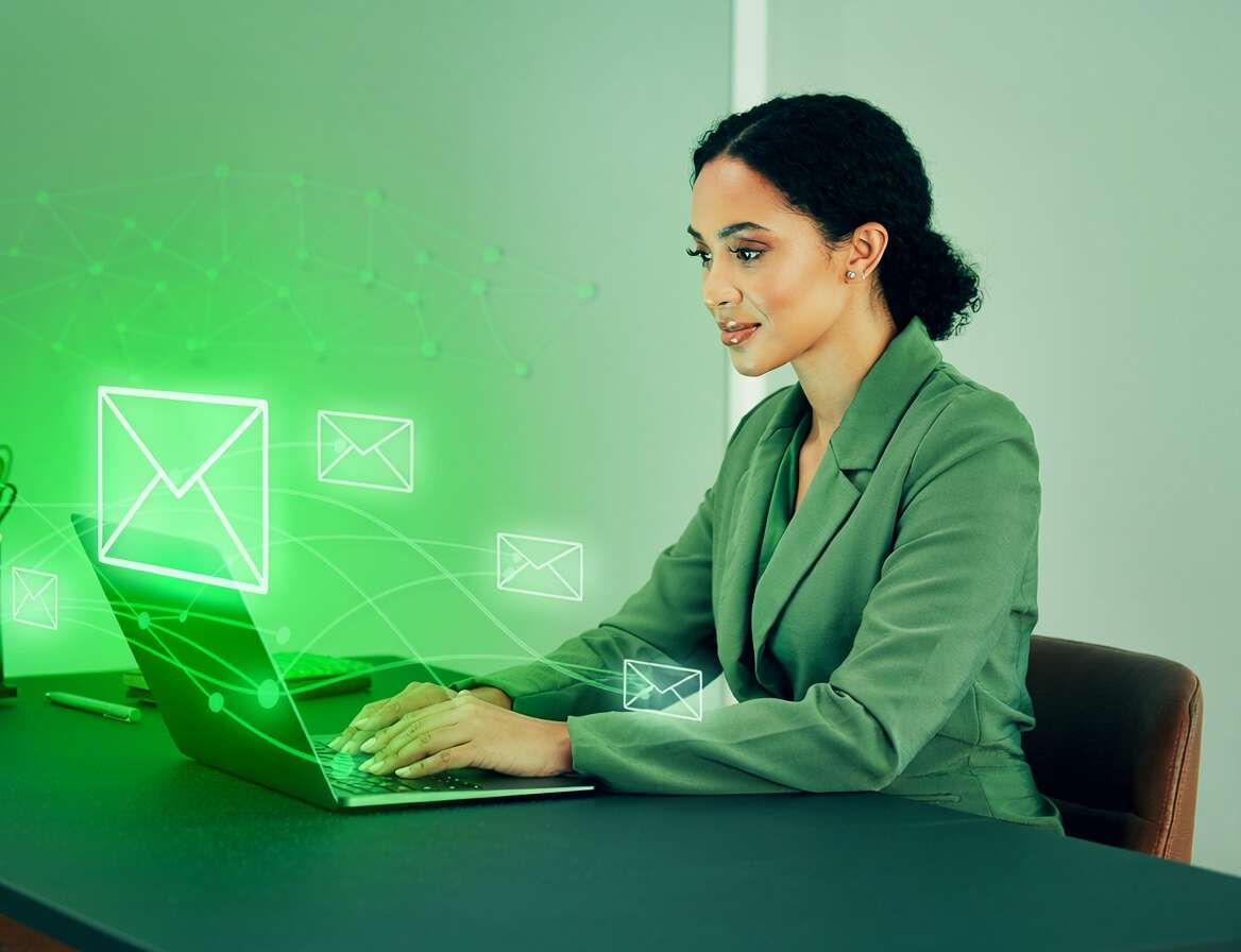 Mulher usando laptop com ícones de email em verde.