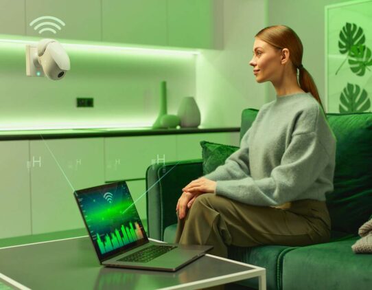 Mulher sentada diante de laptop com luz verde.