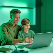 Pai e filho aprendendo juntos em um computador.