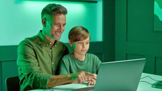 Pai e filho aprendendo juntos em um computador.